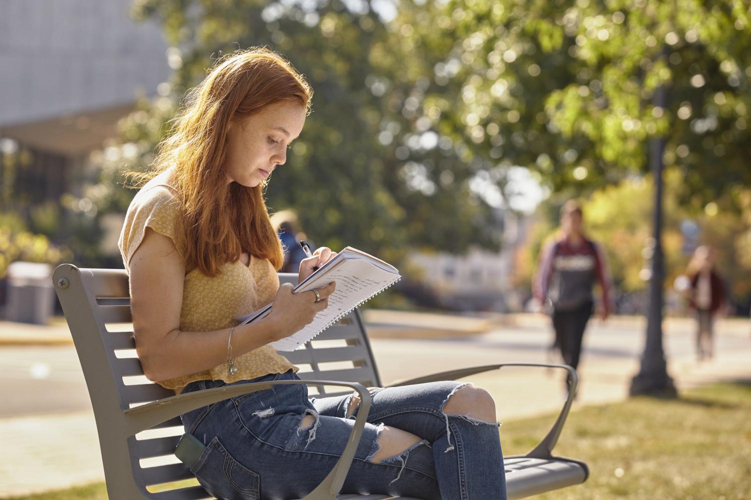 一位<a href='http://3.ngskmc-eis.net/'>全球十大赌钱排行app</a>学院的学生在校园里的长椅上读书.